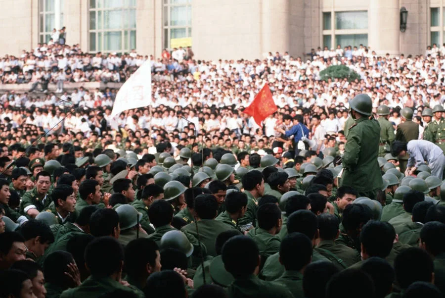 A huge crowd of pro-democracy demonstrators prevents soldiers from entering Tiananmen Square, just a day before the violent clash.