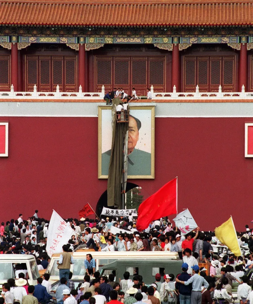 A portrait of Mao Zedong is covered after being defaced with paint, on May 23, 1989. A banner on the bottom reads “This is not done by students.”
