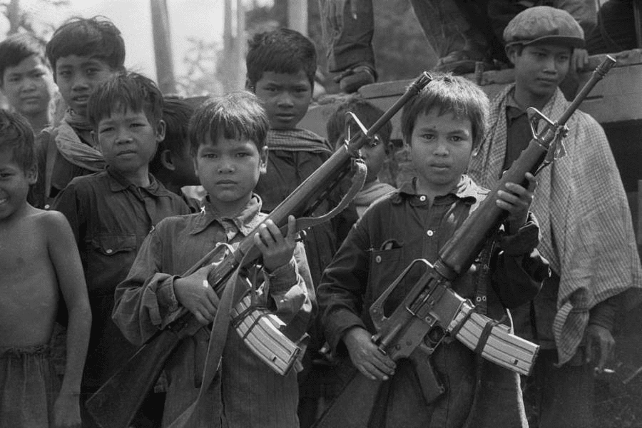 Child soldiers working for the Khmer Rouge show off their machine guns.