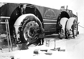 Radio operator Sergeant Felix Ferranto, using a torch to thaw the wheel motors of the Antarctic Snow Cruiser