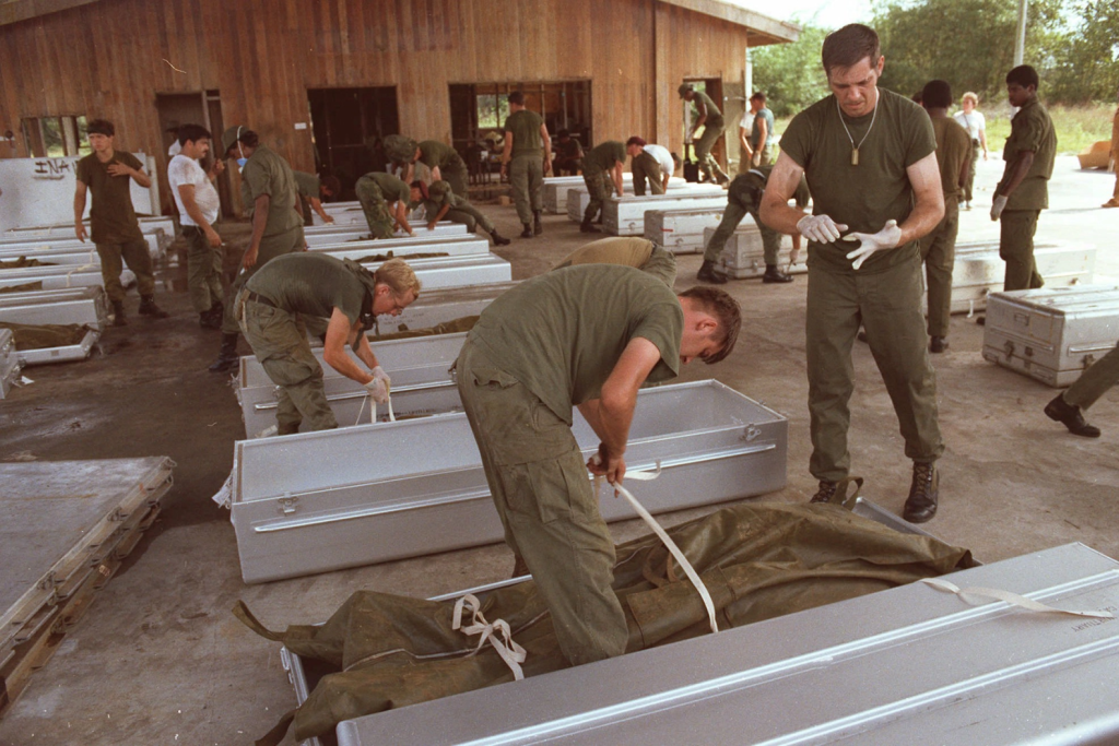 U.S. military personnel place bodies in coffins at the airport in Georgetown, Guyana, in November 1978.